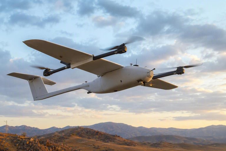 Industrial hybrid VTOL fixed-wing drone in profile with an annotated battery power-profile curve overlay showing a takeoff spike followed by a flat cruise sustain line